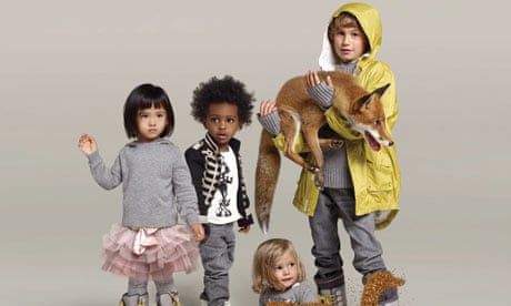 Quatre enfants en vêtements de marque stylés posent avec un renard.