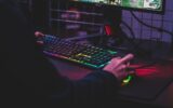 Joueur utilisant un clavier rétroéclairé et une souris devant un écran