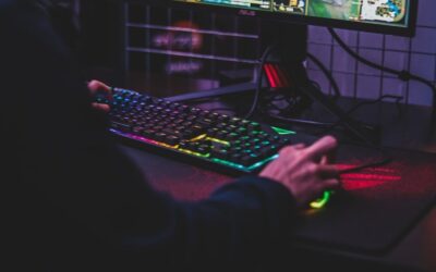 Joueur utilisant un clavier rétroéclairé et une souris devant un écran