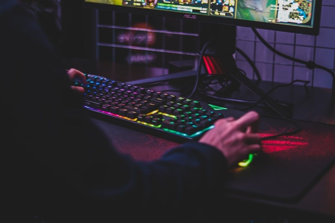 Joueur utilisant un clavier rétroéclairé et une souris devant un écran