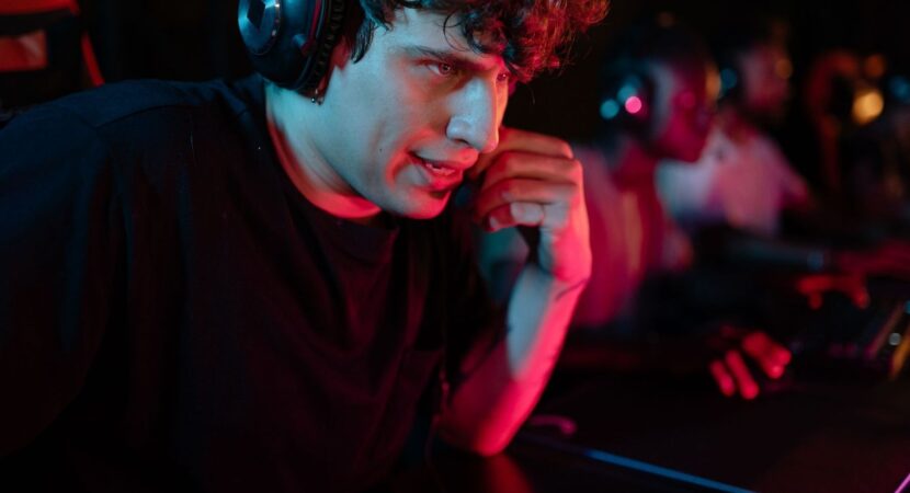 Joueur d’esport concentré, casque sur les oreilles, devant son écran