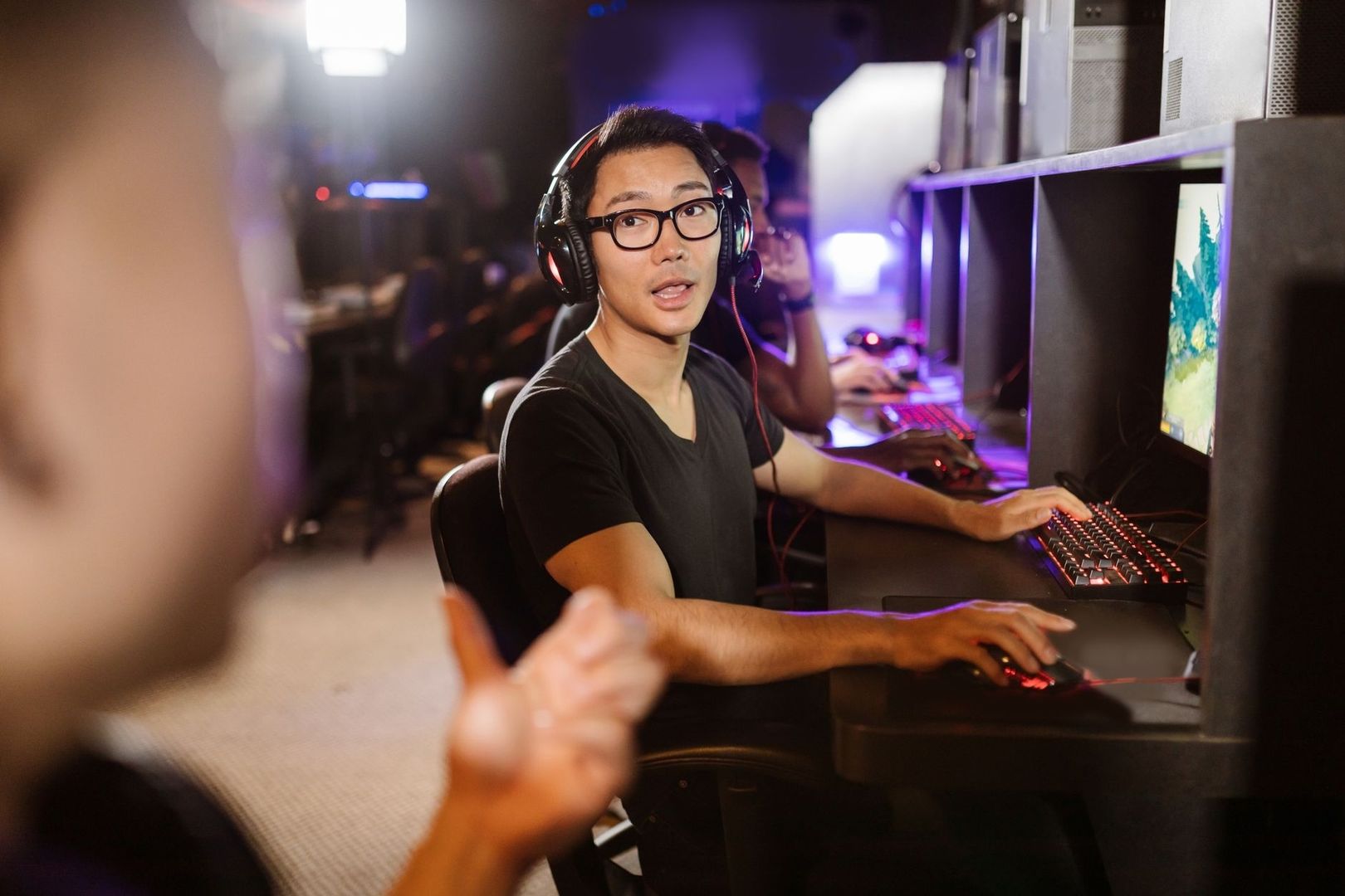Joueur concentré devant un écran, casque audio et souris en main